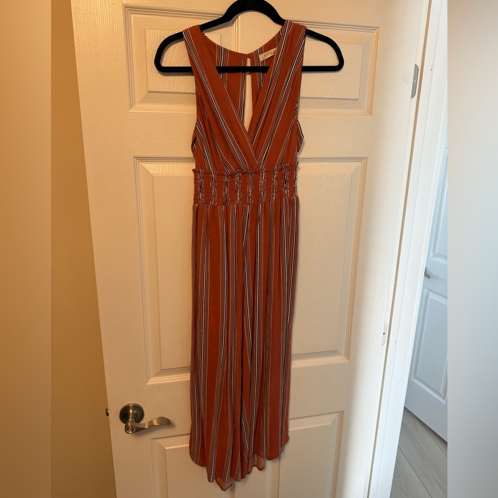 From a boutique, pants romper with criss cross side detail
Coral color